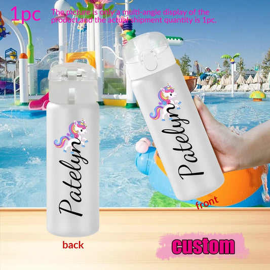 Two clear water bottles with personalized names and unicorn designs, one held by a hand in front of a pool.