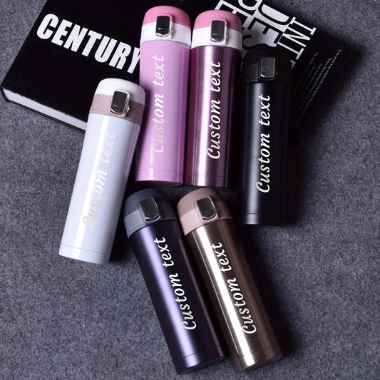 Set of personalized tumblers with 'Custom text' on a gray surface.
