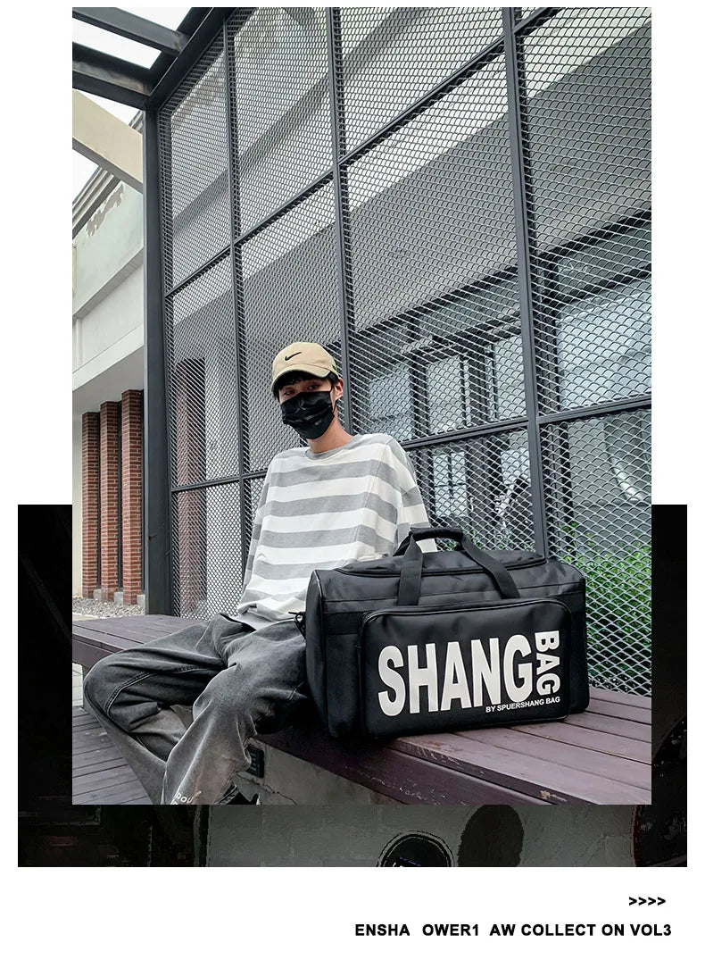 A person sitting on a bench in front of a metal mesh wall wears a striped shirt and gray pants, with a large black duffel bag featuring bold white 'SHANG BAG' text placed on the bench beside them.