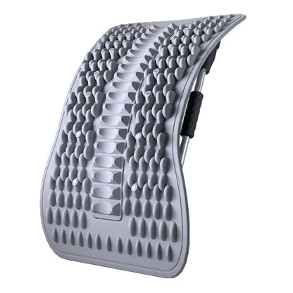 A curved gray contoured lumbar support pad with raised silicone bumps and a black side adjustment strap, shown on a plain white background.