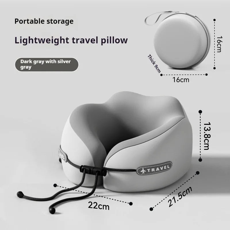 A portable travel neck pillow shown on a light gray background with dimension callouts and text. The main product is a soft, curved travel pillow in dark gray with silver-gray trim and a black strap.