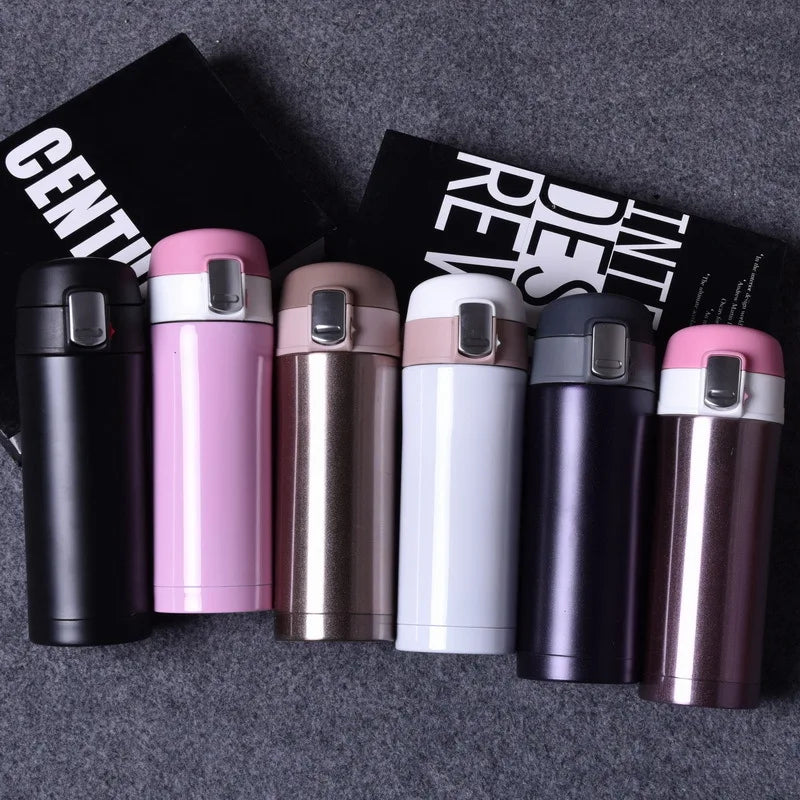 Set of colorful insulated travel mugs on a dark textured surface