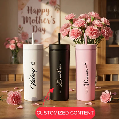 Three personalized tumblers with names 'Valerie', 'Lenevia', and 'Nelena' on a table with pink flowers.