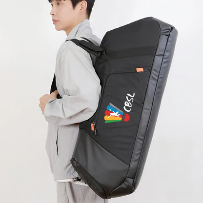A man wearing a light gray jacket is shown from the side, carrying a large black sports equipment bag on his back. The bag has a colorful logo with the text 'CBSL' on the front pocket, set against a plain white background.