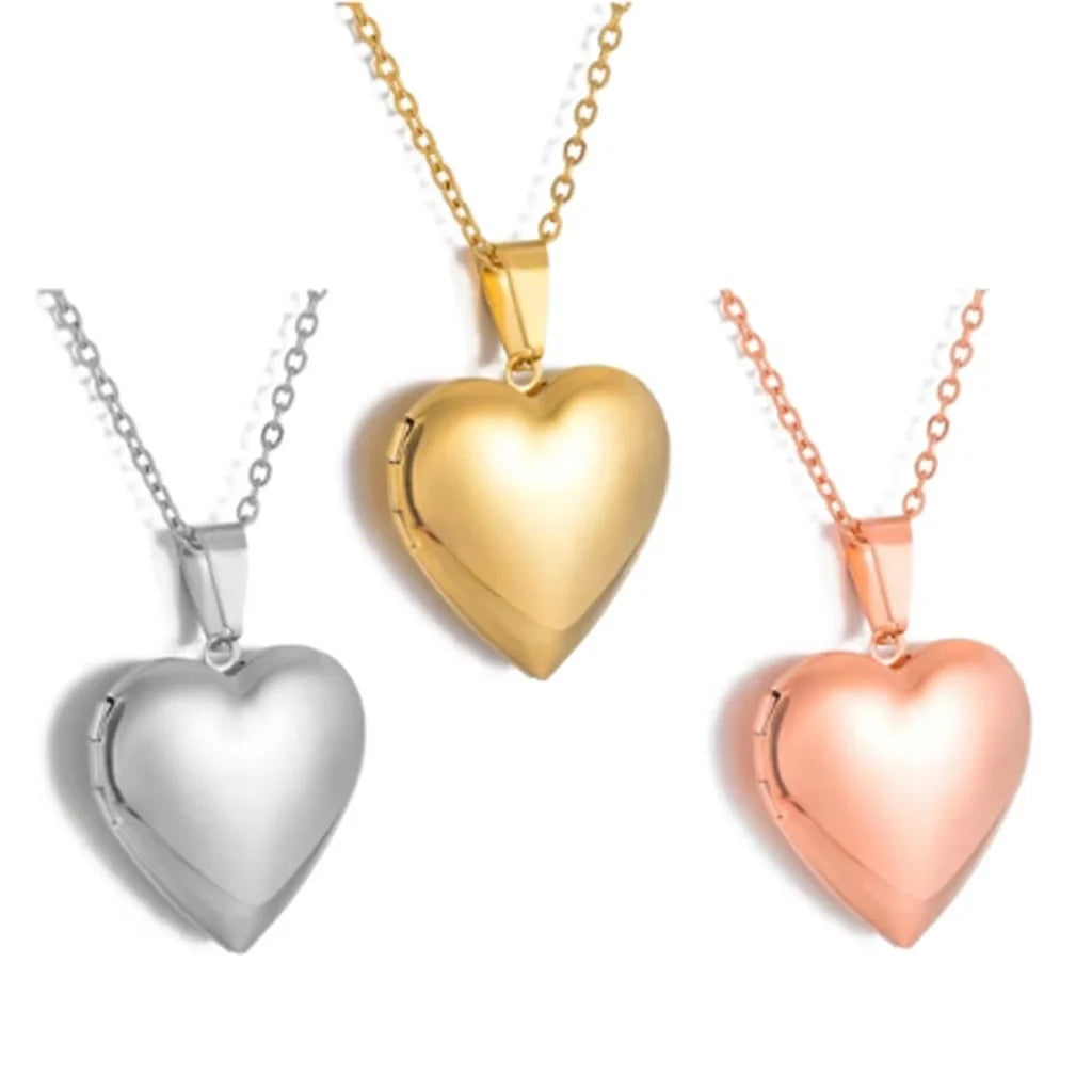 Three heart-shaped pendants in gold, silver, and rose gold on necklaces.