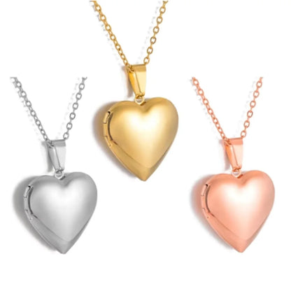 Three heart-shaped pendants in gold, silver, and rose gold on necklaces.